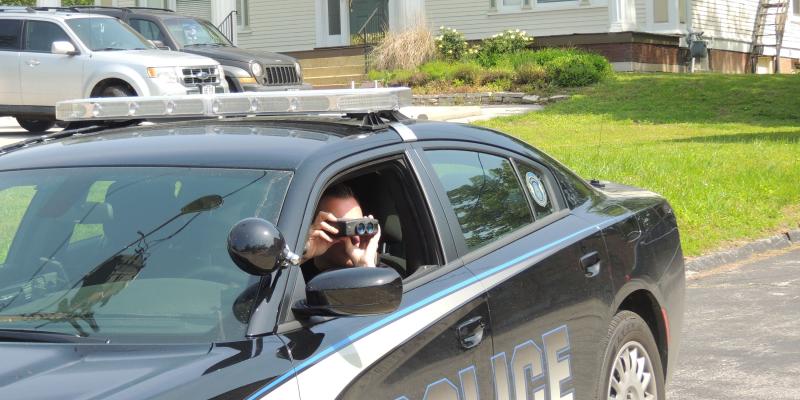 officer using binoculars from police car