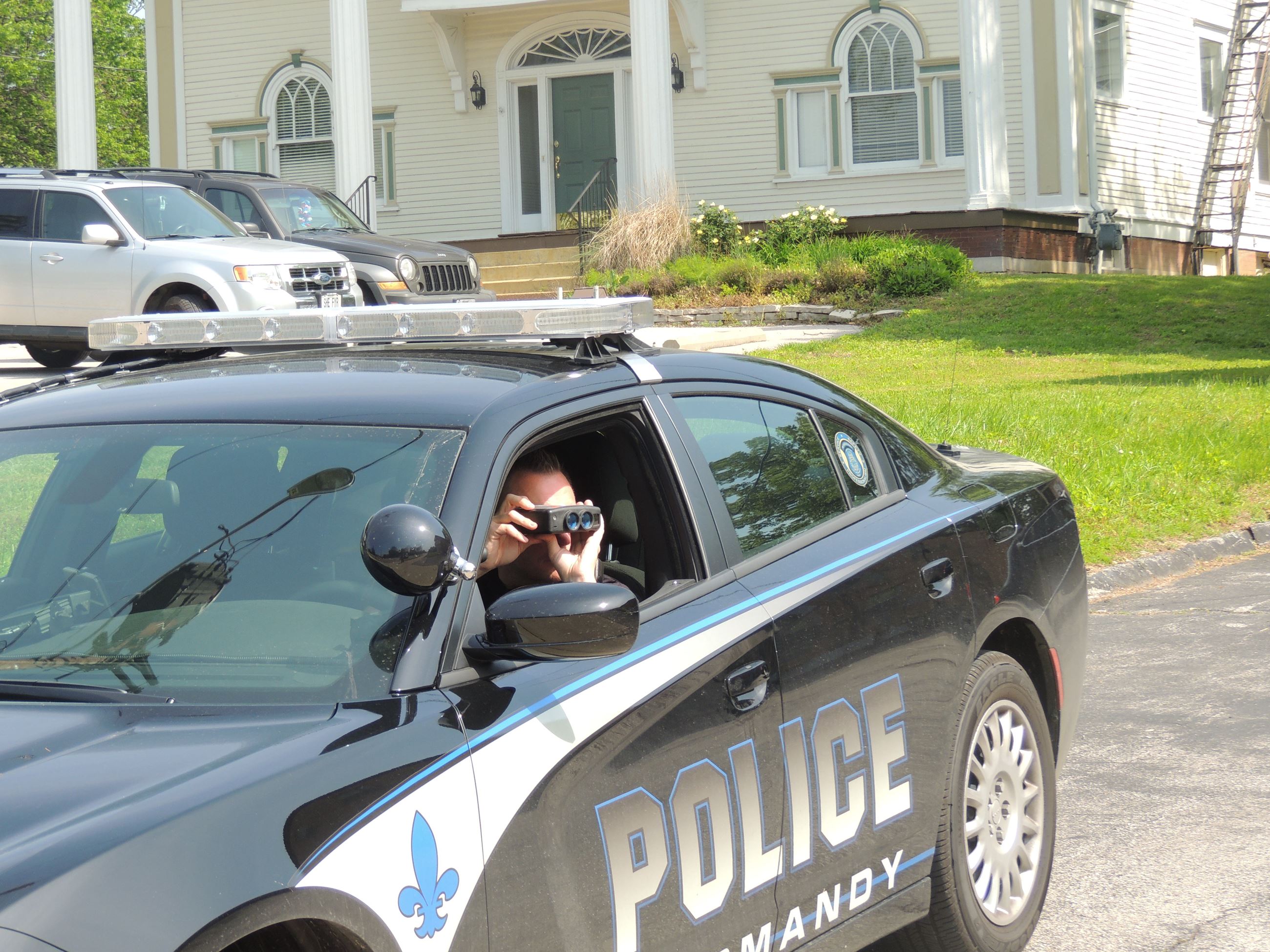 officer using binoculars from police car